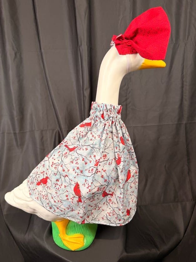 Goose statue wearing cardinal and berry print dress with cardinal print hat – side view