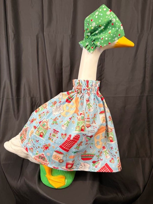 Goose statue wearing light blue Christmas baking dress and green snowflake hat – side view