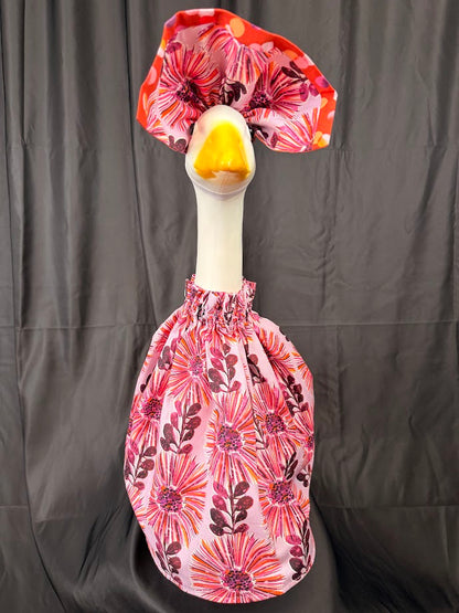 Goose statue wearing pink floral dress and red polka dot hat – side view