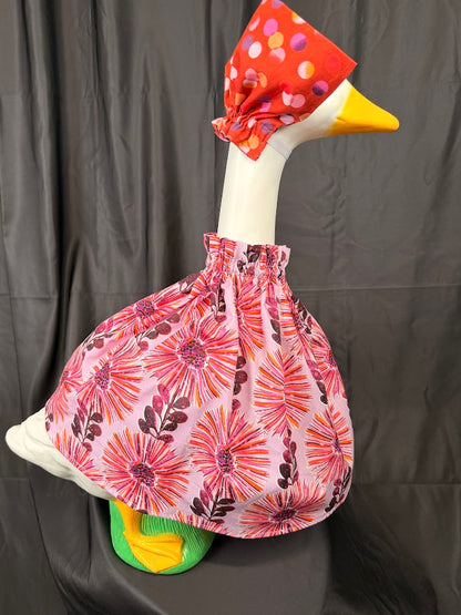 Goose statue wearing pink floral dress and floral hat – side profile view