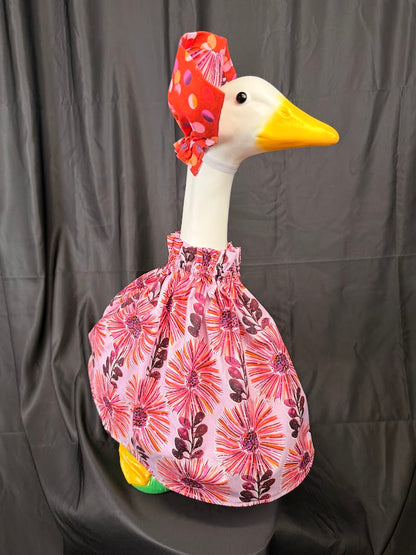 Goose statue wearing pink floral dress and floral hat – front view