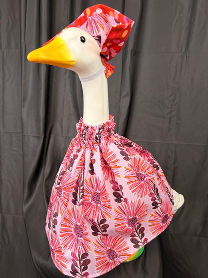 Goose statue wearing pink floral dress and red polka dot hat – three-quarter view