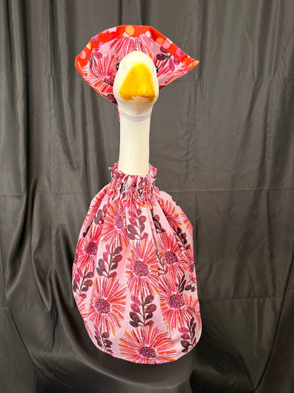 Goose statue wearing pink floral dress and large floral hat – front view