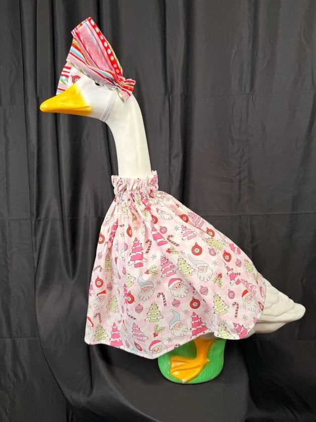 Goose statue wearing pink Christmas print dress and striped hat – back side view