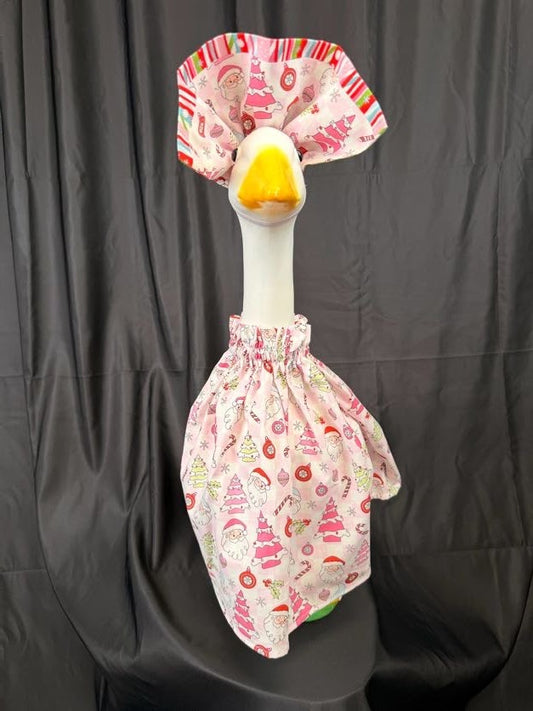 Goose statue wearing pink Christmas print dress and large striped hat – front view