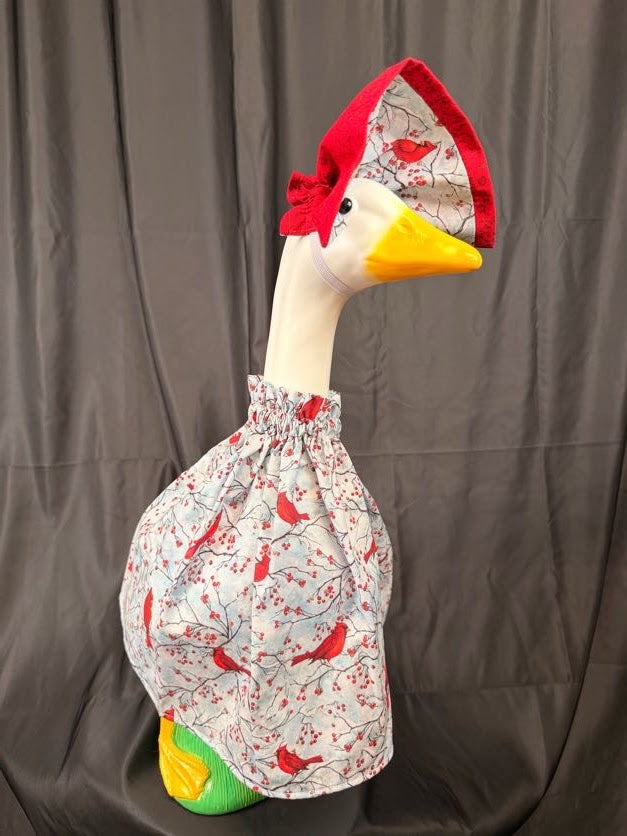Goose statue wearing cardinal and berry print dress with large cardinal print hat – front view