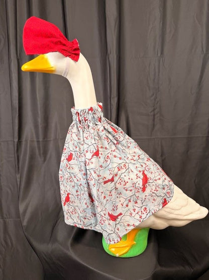 Goose statue wearing cardinal and berry print dress with cardinal print hat – angled view