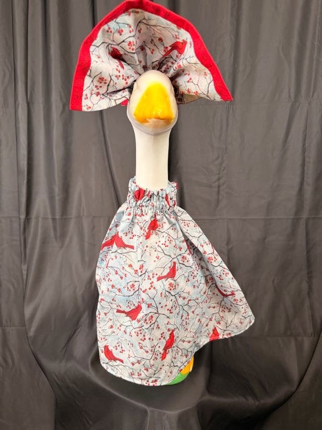 Goose statue wearing cardinal and berry print dress with wide cardinal print hat – front view