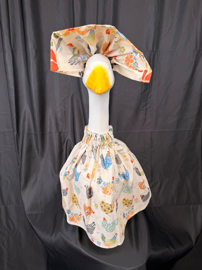 Goose statue wearing cream chicken print dress and floral hat – side view