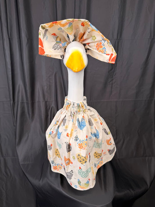 Goose statue wearing cream chicken print dress and floral hat – side view
