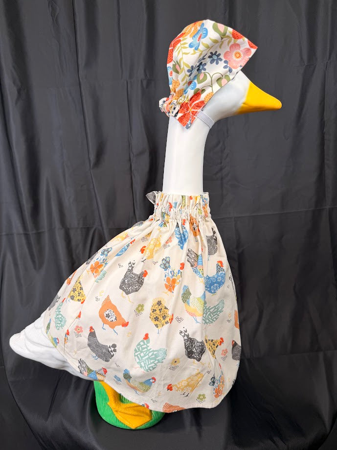 Goose statue wearing cream chicken print dress and large chicken print hat – front view