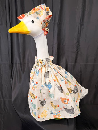 Goose statue wearing cream chicken print dress and wide chicken print hat – front view