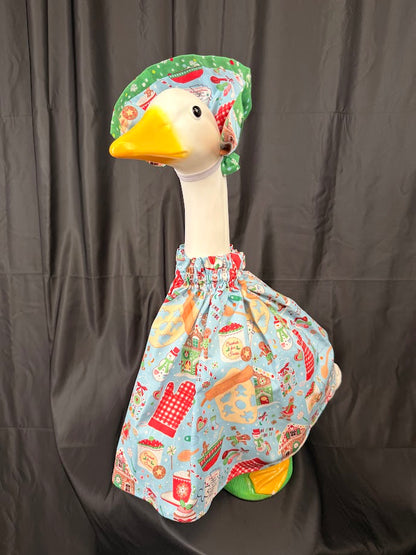 Goose statue wearing light blue Christmas baking dress and green hat – side profile