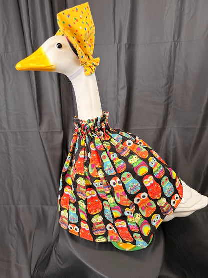 Goose statue wearing black colorful owl print dress and yellow polka dot hat – three-quarter view