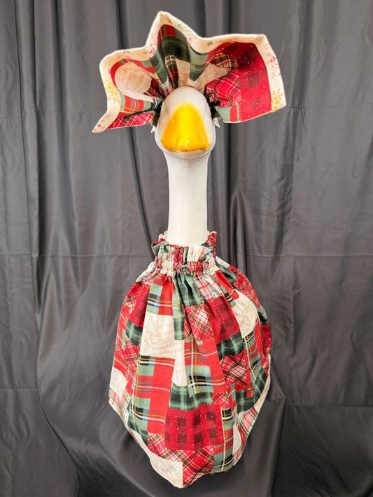 Goose statue wearing red and green plaid patchwork dress and large reversible hat – front view