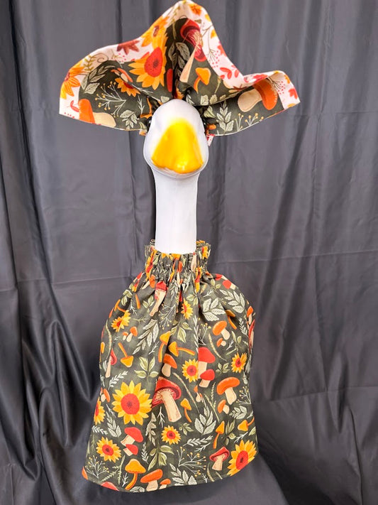 Goose statue wearing olive green mushroom and sunflower dress and wide reversible hat – front view