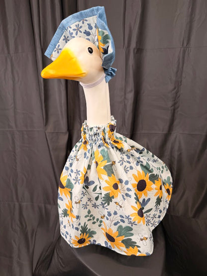 Goose statue wearing white sunflower bee botanical dress and reversible sunflower hat – three-quarter view