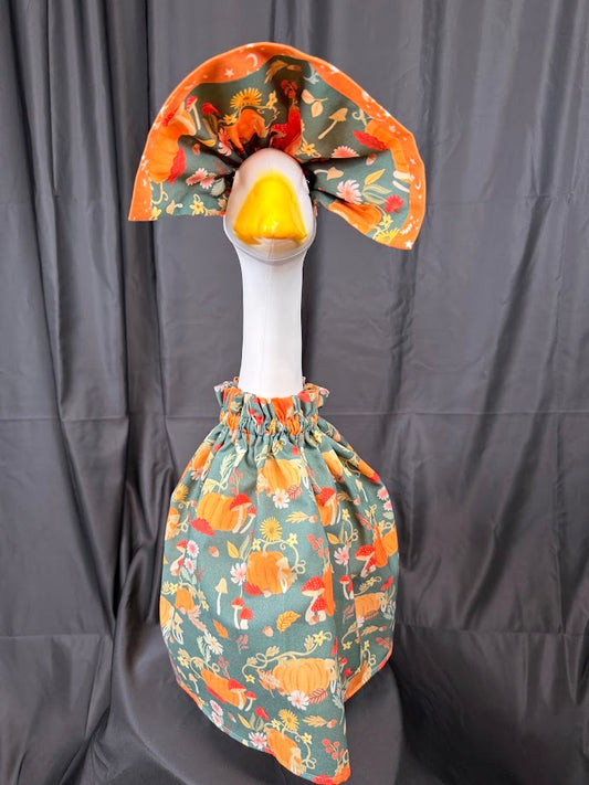 Goose statue wearing teal harvest fox and pumpkin dress and large reversible orange hat – front view